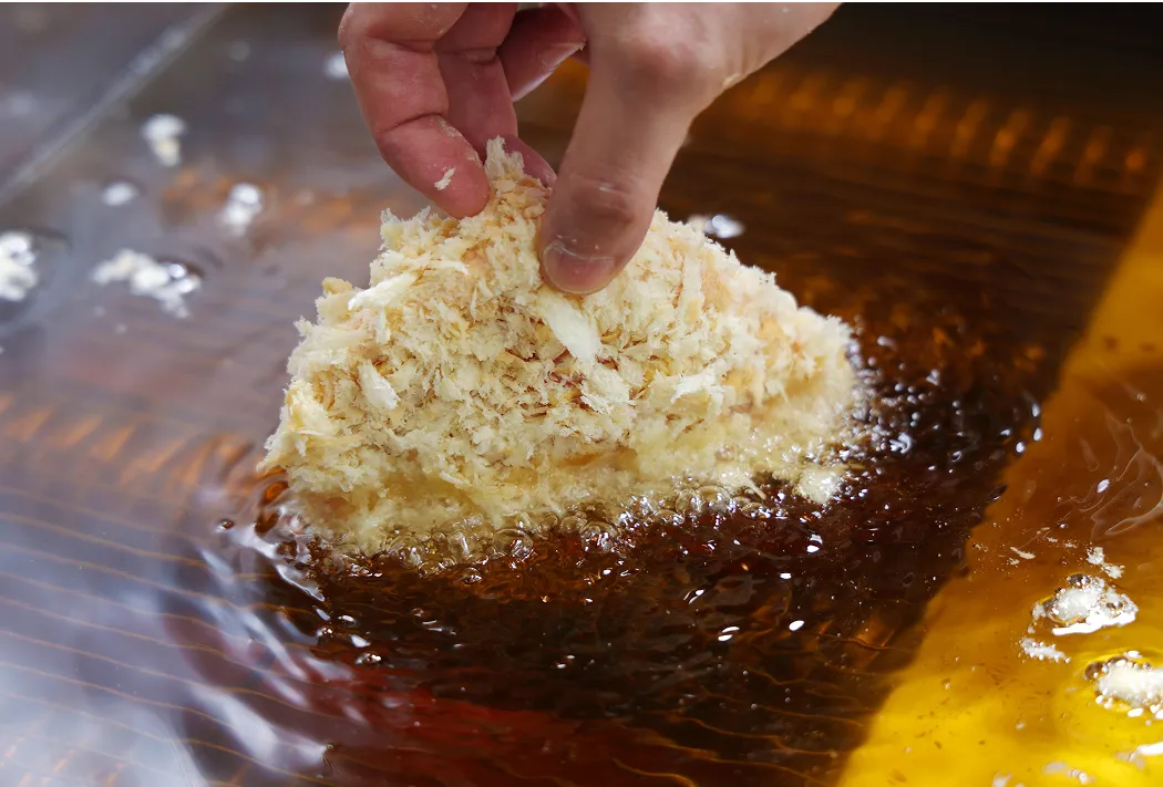 とんかつを油で揚げる様子